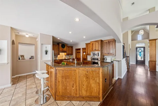 a view of a kitchen with kitchen island granite countertop lots of counter top space and stainless steel appliances