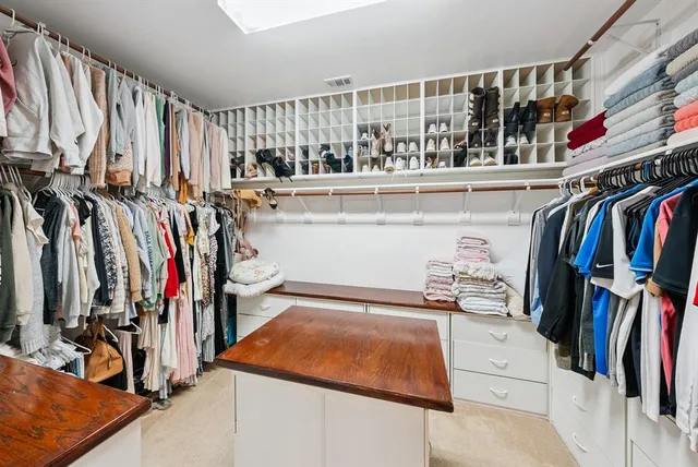 a view of walk in closet with clothes and shoes