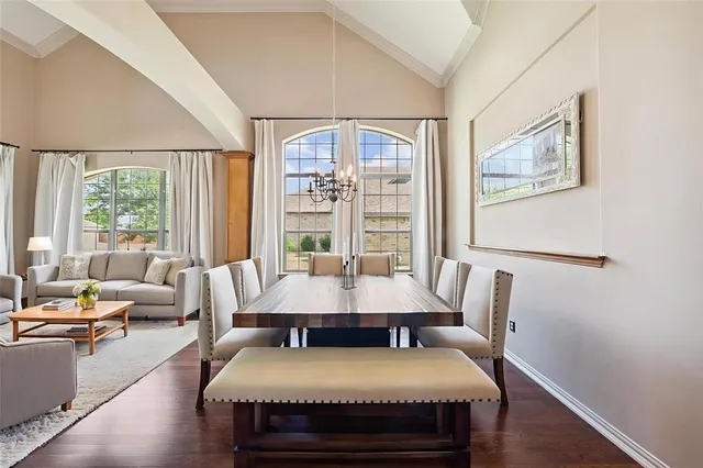 a view of a dining room with furniture a chandelier and wooden floor