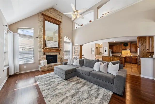 a living room with furniture large window and wooden floor