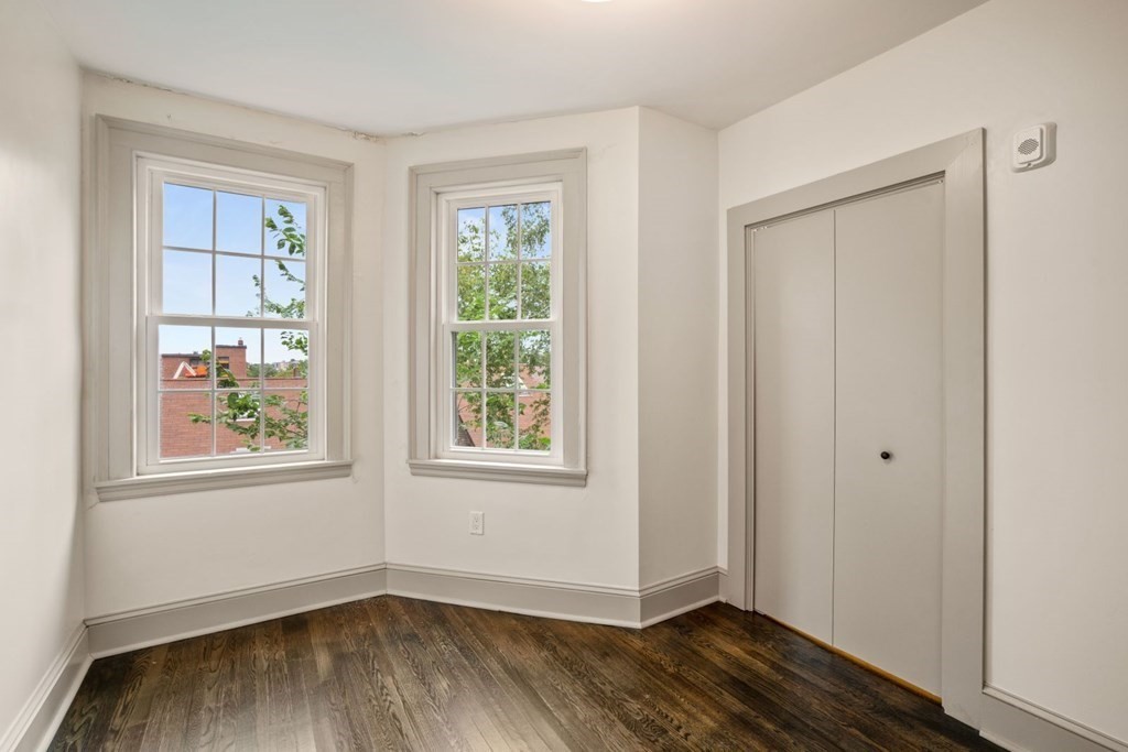 9 Dana Street, Unit 33 Cambridge, MA 02138 - Photo 12 of 15 an empty room with wooden floor and windows