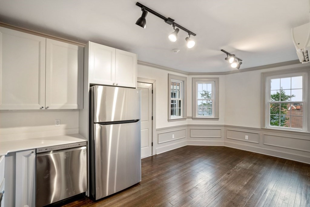 9 Dana Street, Unit 33 Cambridge, MA 02138 - Photo 3 of 15 a kitchen with stainless steel appliances granite countertop a refrigerator a sink and a large window