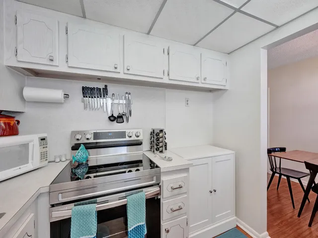 a kitchen with white cabinets and appliances