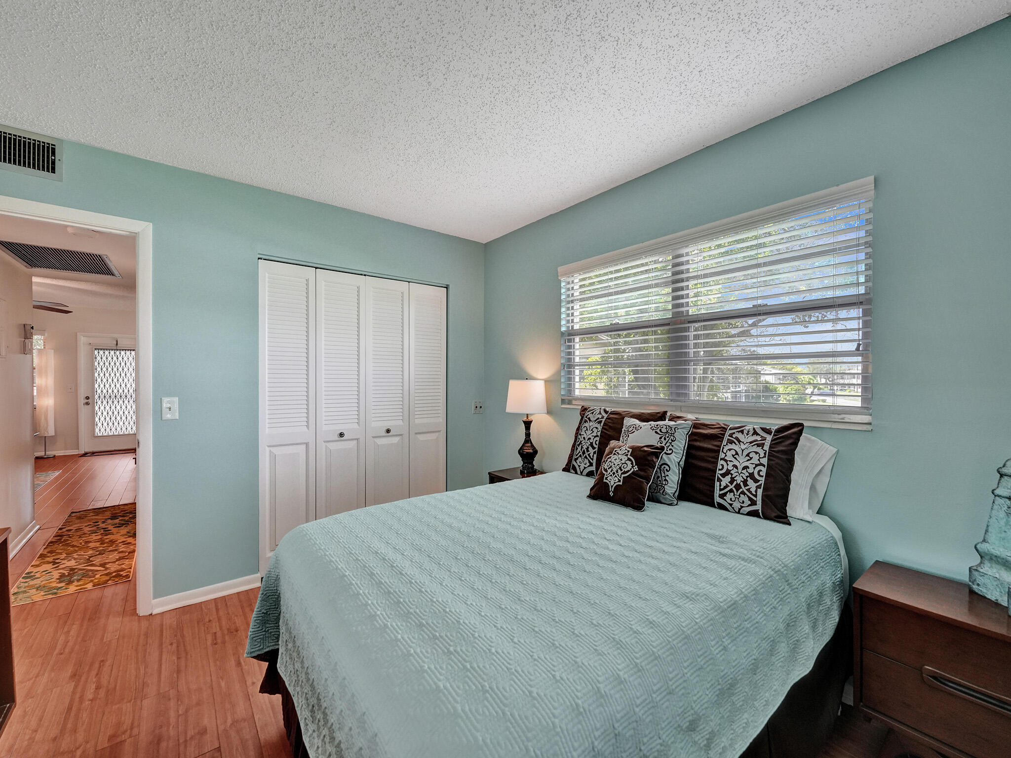 232 Farnham J, Unit 232 Deerfield Beach, FL 33442 - Photo 18 of 38 a bedroom with a bed and wooden floor