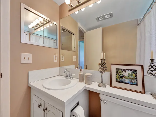 a bathroom with a sink and a mirror with a painting on the wall
