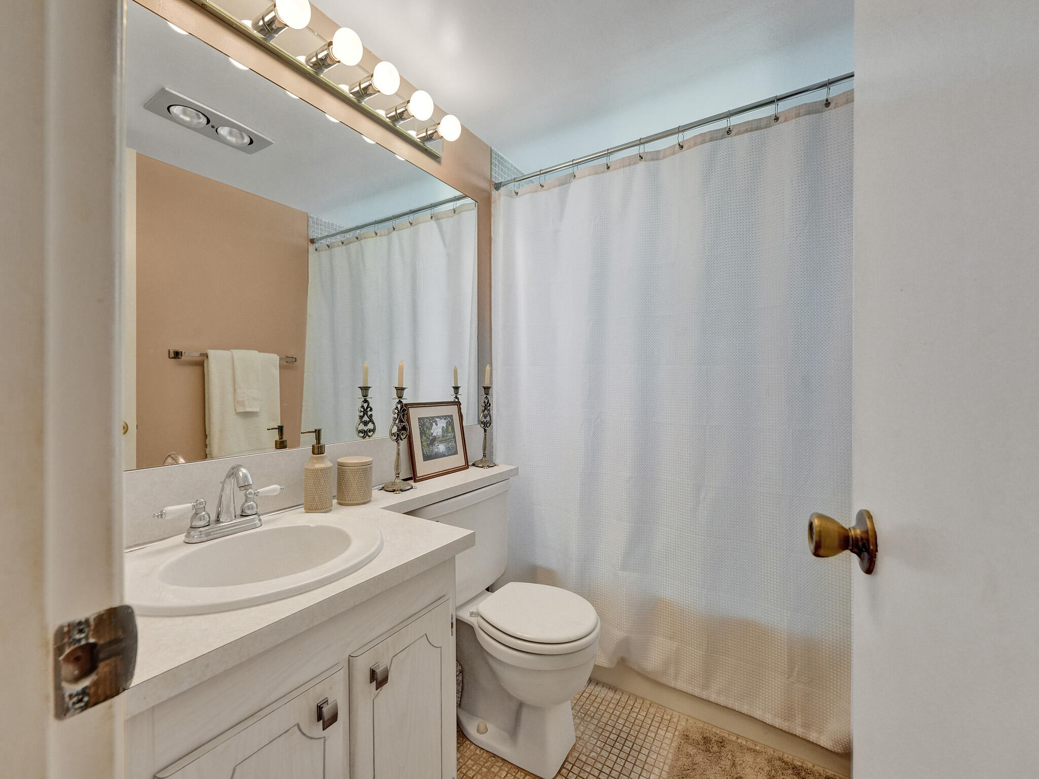 232 Farnham J, Unit 232 Deerfield Beach, FL 33442 - Photo 30 of 38 a bathroom with a sink a toilet a mirror and shower curtain