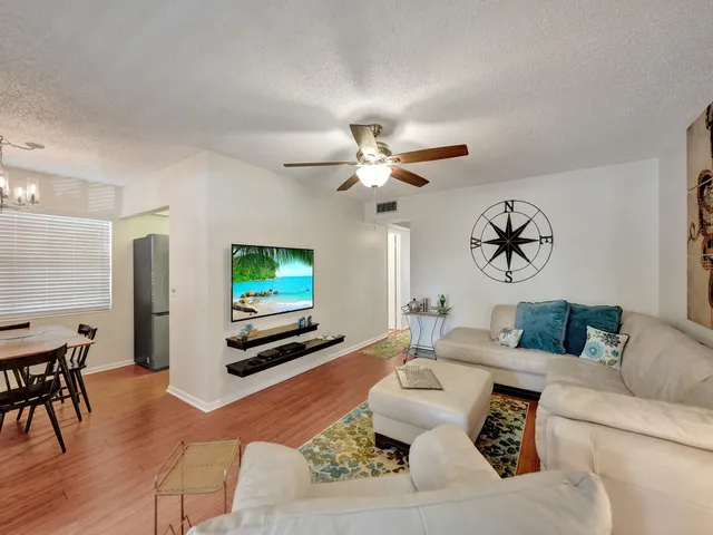 a living room with furniture a flat screen tv and a window
