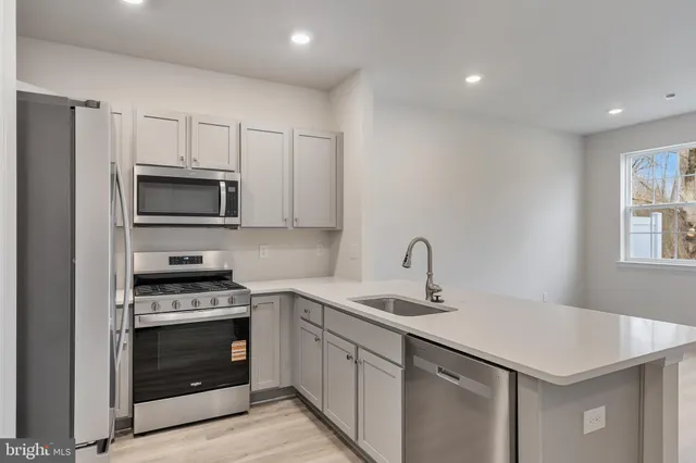 a kitchen with a sink stove and microwave