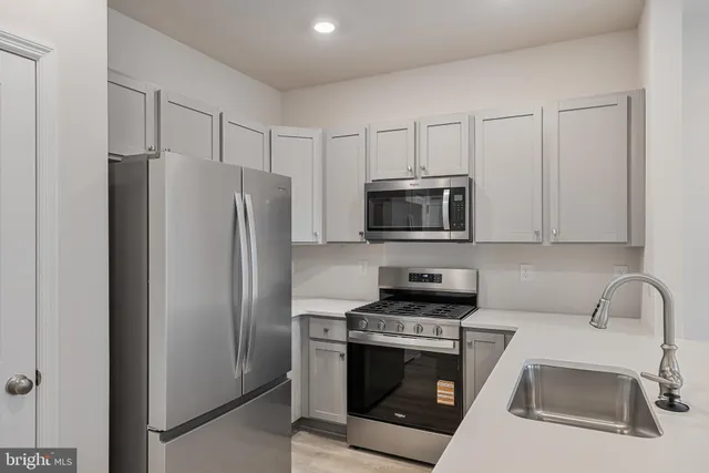 a kitchen with stainless steel appliances a refrigerator stove and microwave