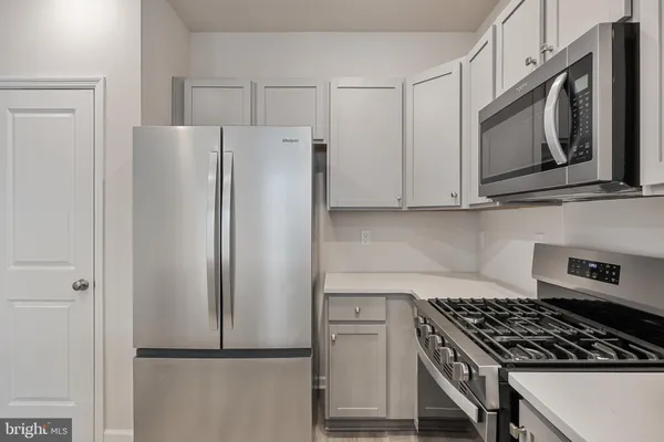 a kitchen with stainless steel appliances granite countertop a refrigerator and a stove top oven