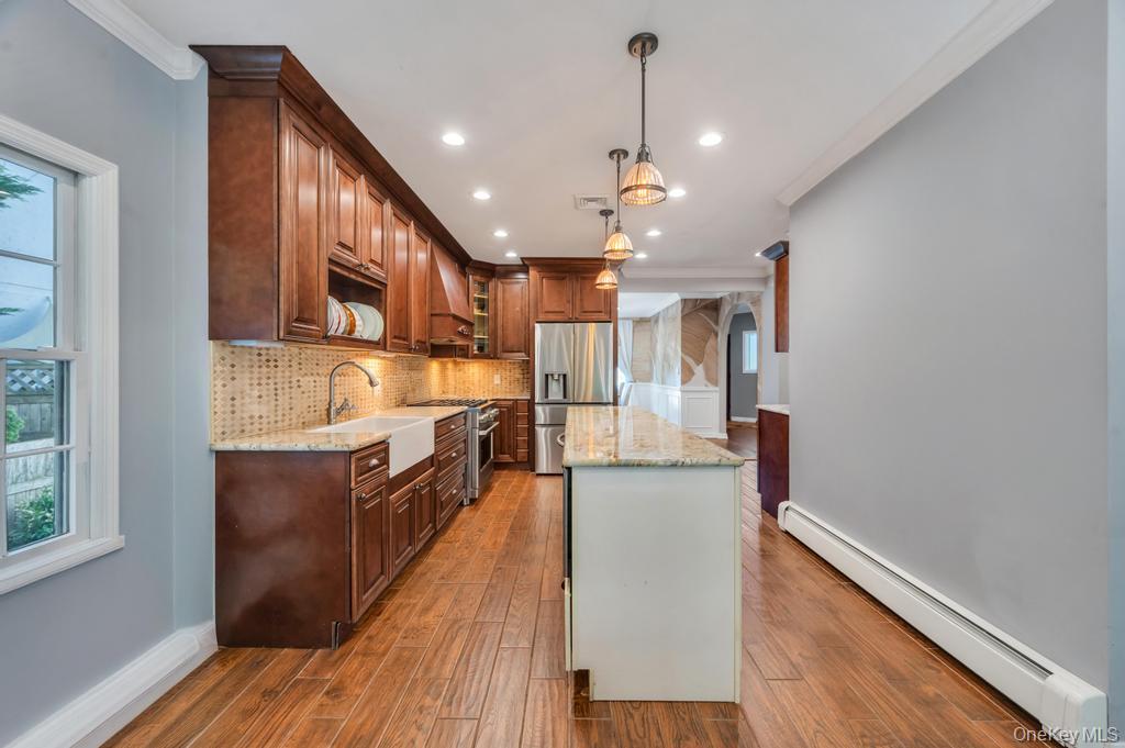 357 Wynsum Avenue Merrick, NY 11566 - Photo 18 of 40 a large kitchen with stainless steel appliances lots of counter space and wooden floor