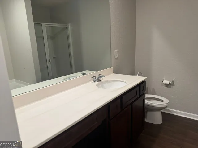 a bathroom with a sink a toilet and a mirror