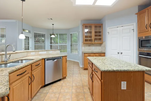 a kitchen with stainless steel appliances granite countertop a sink stove and cabinets