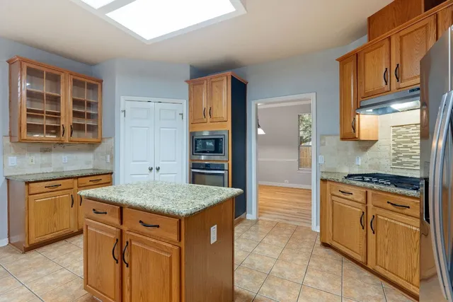 a kitchen with stainless steel appliances granite countertop a stove a sink and a refrigerator