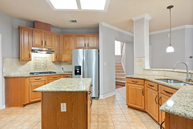 a kitchen with stainless steel appliances granite countertop a sink refrigerator and cabinets