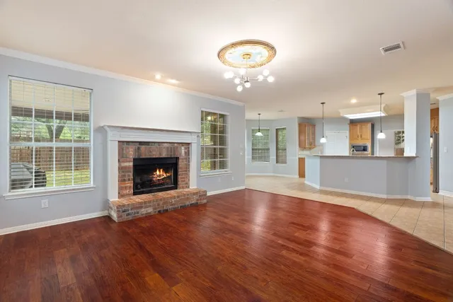 an empty room with wooden floor and a fireplace