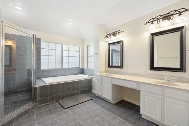 a bathroom with a tub sink shower and mirror