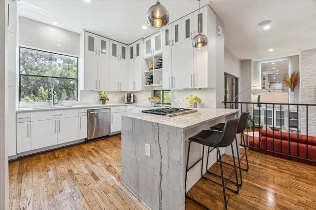 a kitchen with stainless steel appliances granite countertop a stove a sink and a refrigerator