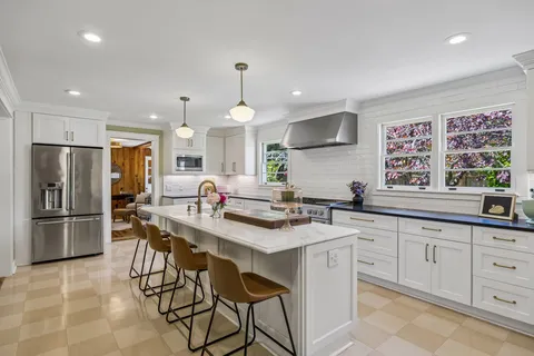 a kitchen with stainless steel appliances a sink a stove a refrigerator and cabinets