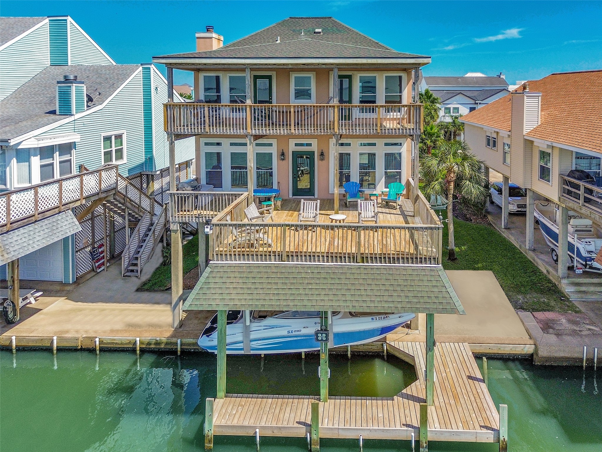 247 Isles End Road Tiki Island, TX 77554 - Photo 1 of 48 Bayfront home features two expansive decks, a covered boathouse with lift and slip, and patio furniture Included.