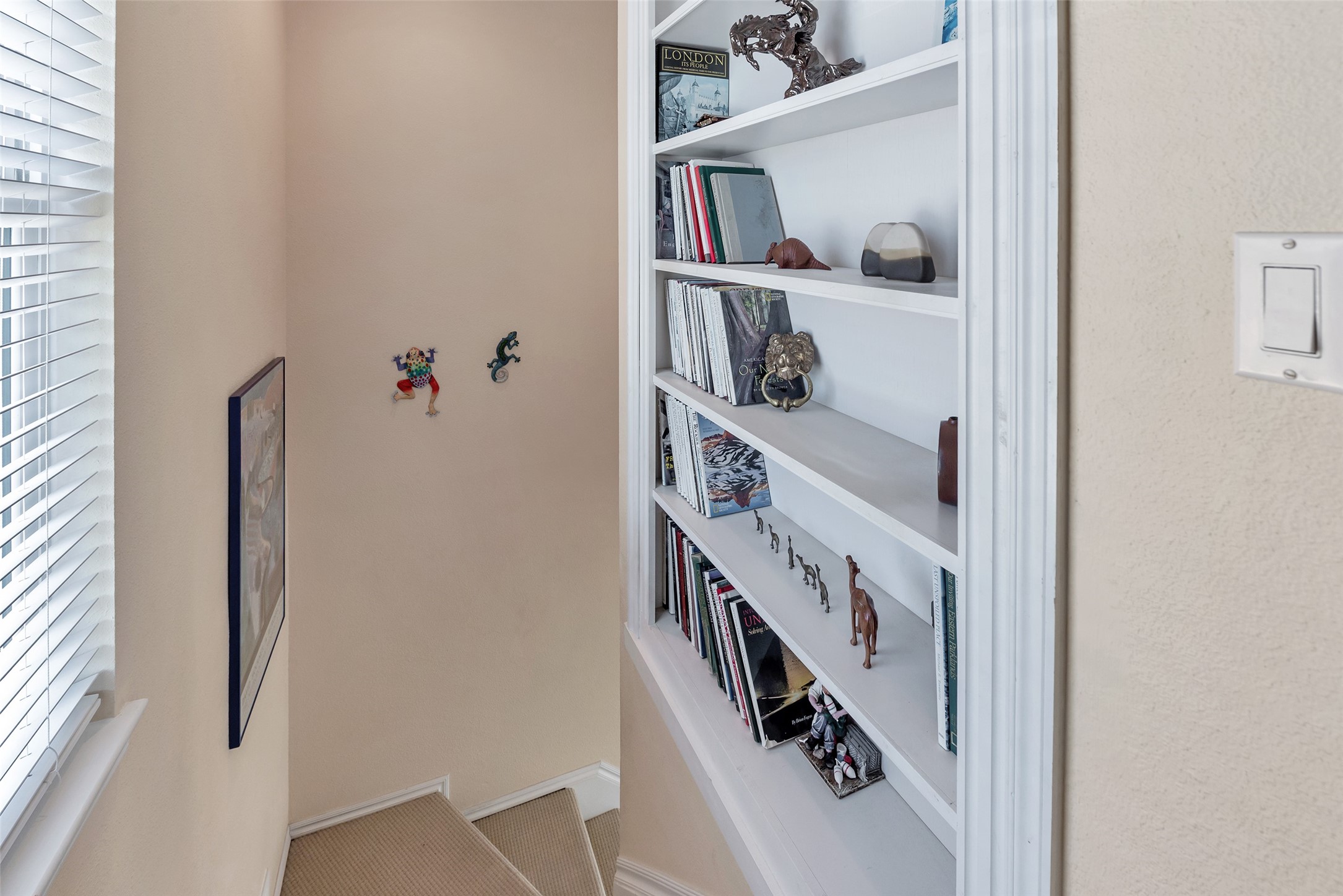 247 Isles End Road Tiki Island, TX 77554 - Photo 16 of 48 Tucked along the stairway landing, this custom built-in shelving adds character and function, perfect for displaying books, art, or collected keepsakes. A thoughtful touch that makes the space feel like home.