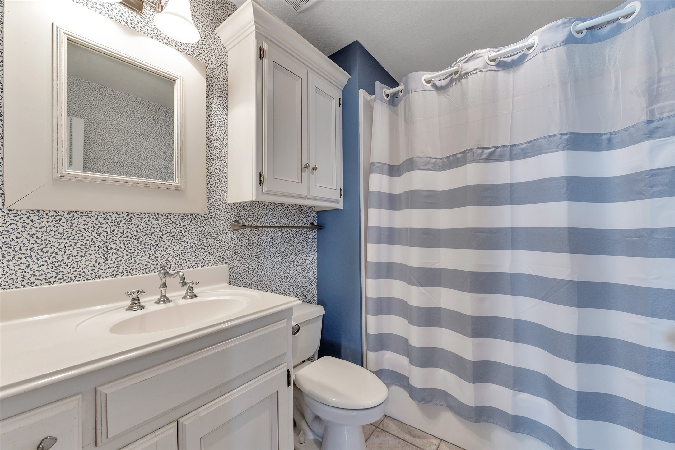 247 Isles End Road Tiki Island, TX 77554 - Photo 19 of 48 a bathroom with a sink a toilet a mirror and shower curtain