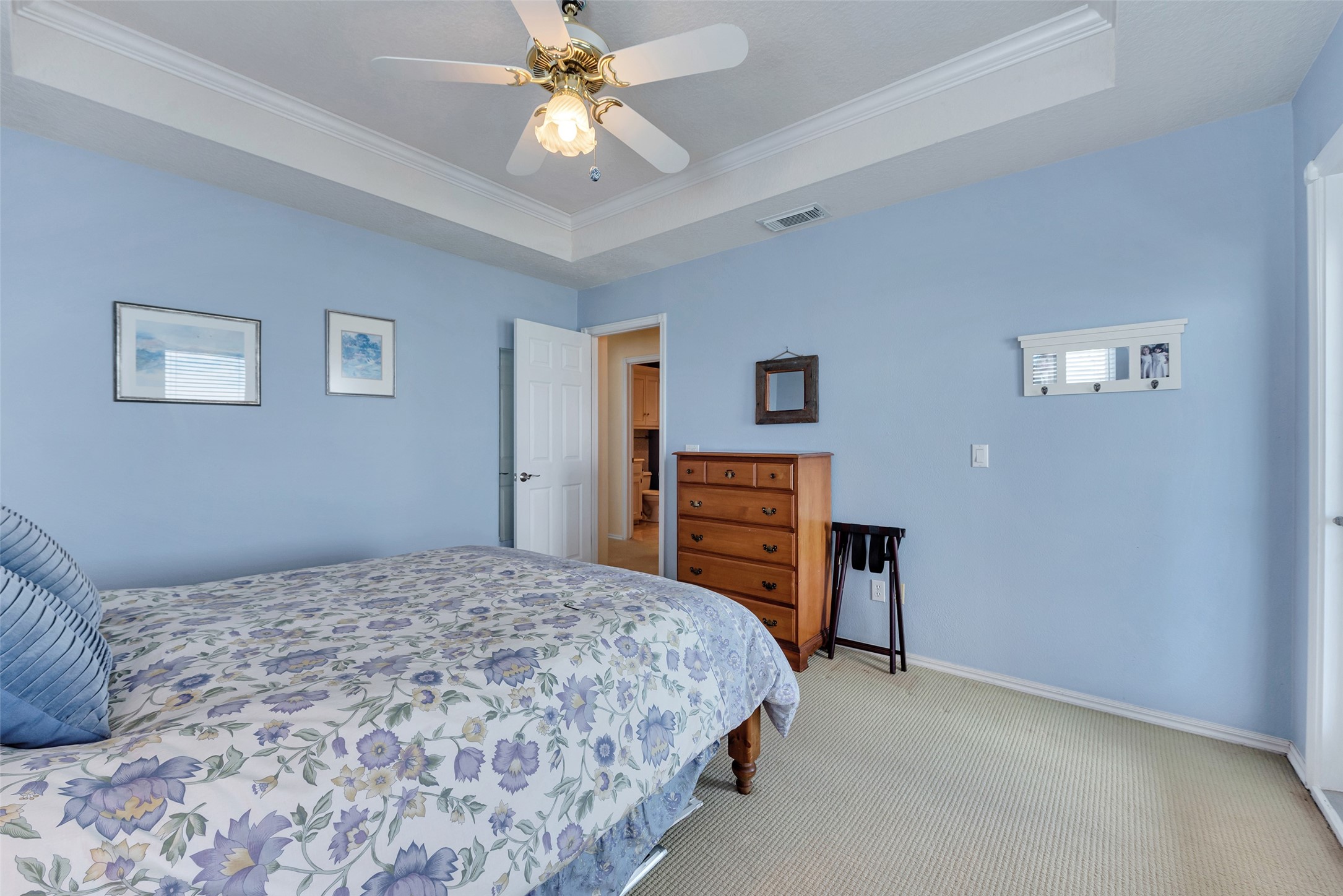 247 Isles End Road Tiki Island, TX 77554 - Photo 21 of 48 a bedroom with a bed and a chandelier