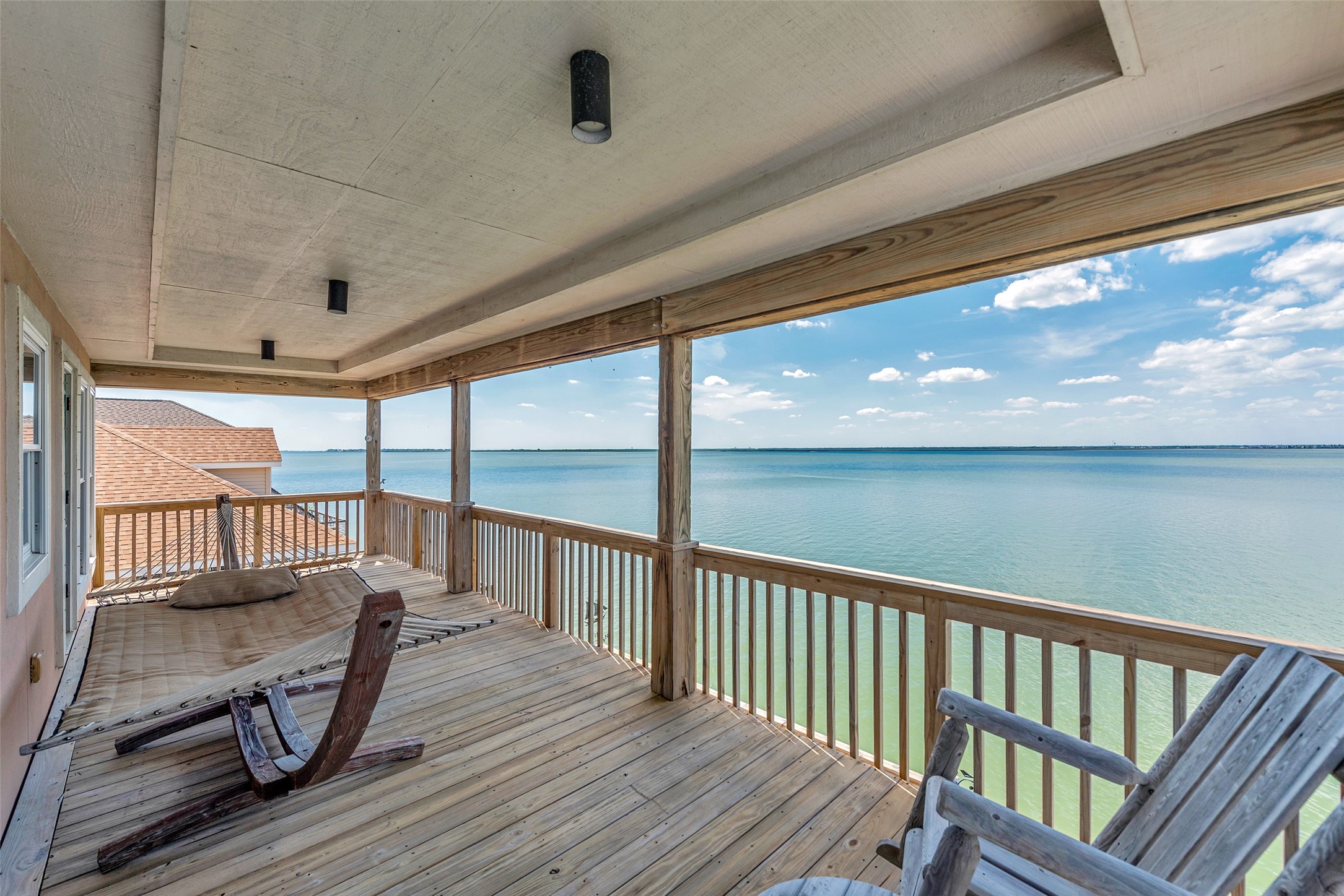 247 Isles End Road Tiki Island, TX 77554 - Photo 26 of 48 Connected to the upstairs bedrooms, enjoy endless water views on the covered balcony. You can catch the breeze, or just take in the view in peace.