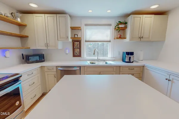a kitchen with kitchen island sink stove and cabinets