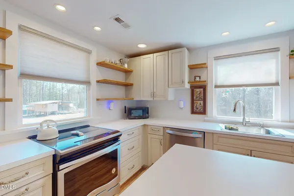 a kitchen with kitchen island a sink appliances cabinets and a counter top space