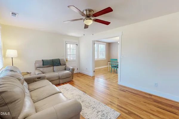 a living room with furniture and a wooden floor