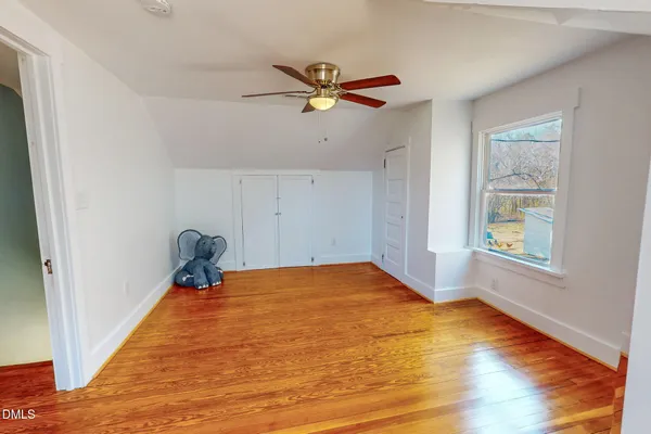 a view of empty room with window and ceiling fan