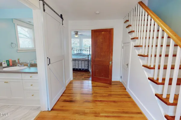 a view of a hallway with wooden floor and staircase