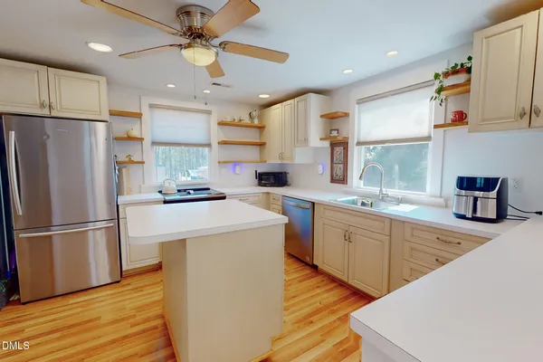a kitchen with a refrigerator a sink and dishwasher with wooden floor