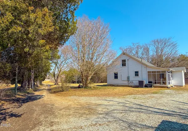 a view of a white house with a large tree