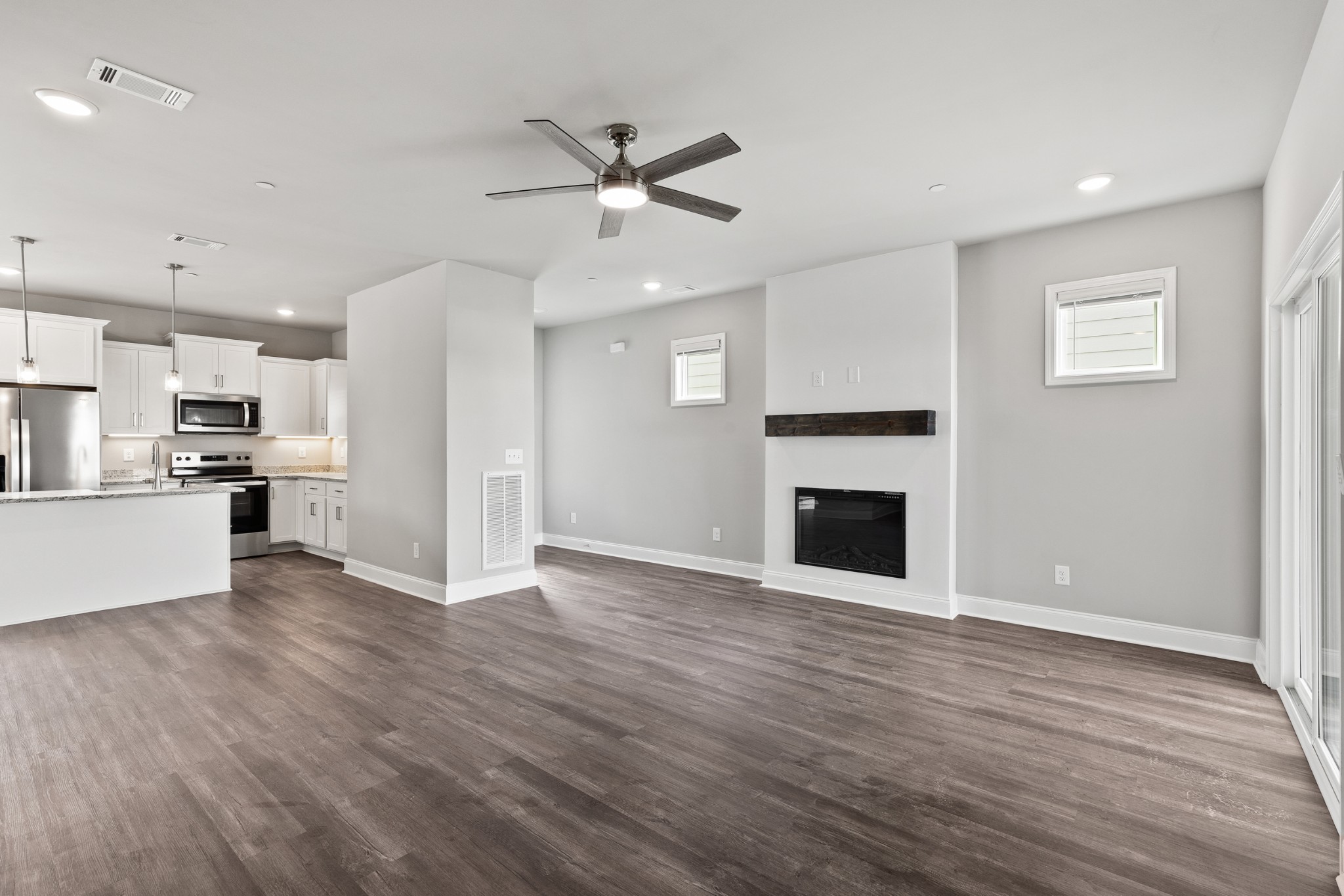 232 Franklin Street Pleasant View, TN 37146 - Photo 12 of 49 an empty room with wooden floor a ceiling fan and kitchen view