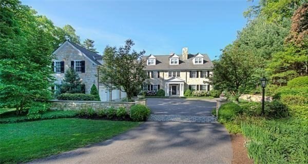 a front view of a house with a yard and a tree