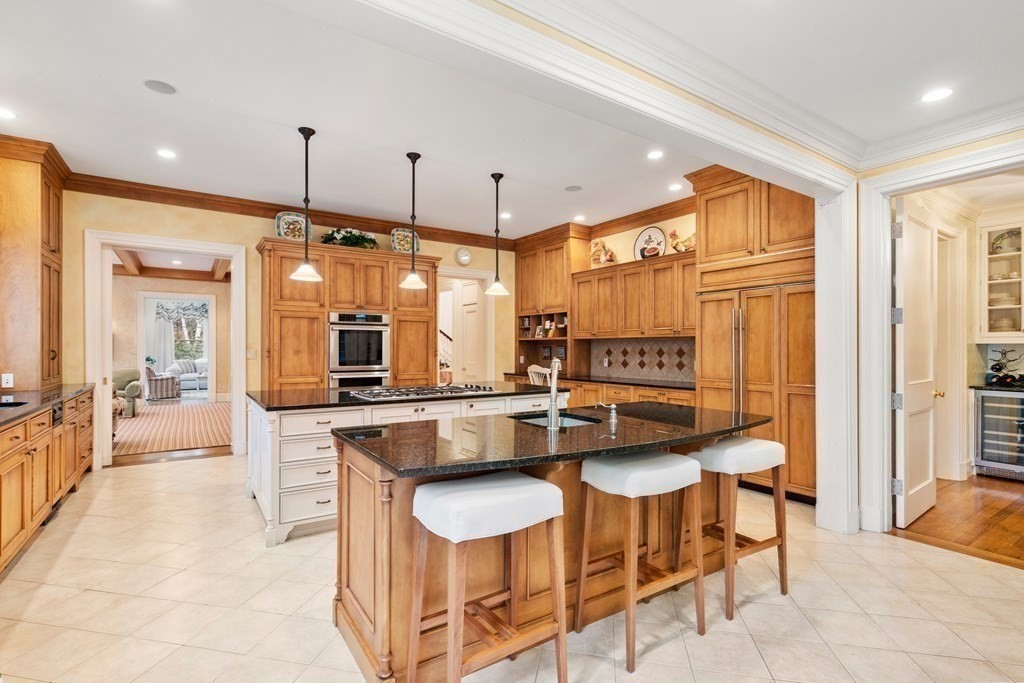 25 Bridle Pth Path Weston, MA 02493 - Photo 11 of 32 a kitchen with granite countertop a table chairs stove and granite counter top