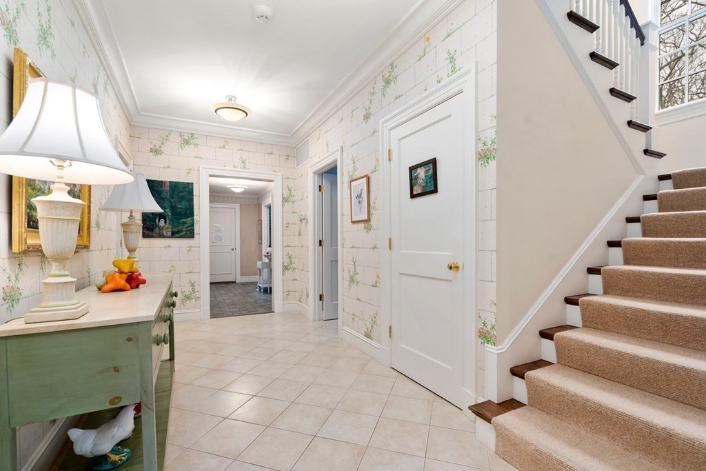 25 Bridle Pth Path Weston, MA 02493 - Photo 14 of 32 a view of a hallway to a livingroom with furniture and staircase