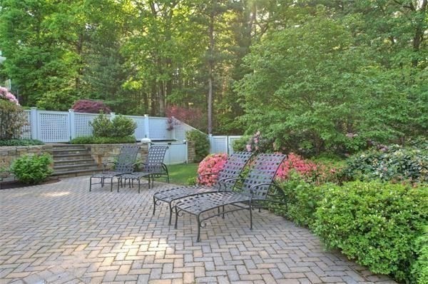 25 Bridle Pth Path Weston, MA 02493 - Photo 26 of 32 a backyard with table and chairs and potted plants