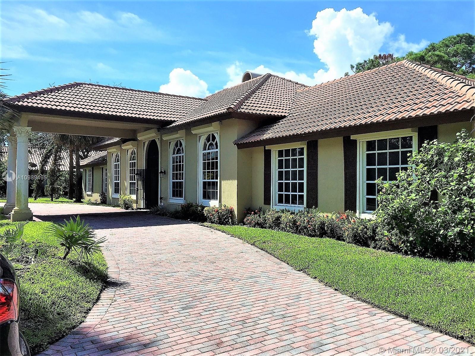 a view of a house with brick walls and floor to ceiling windows