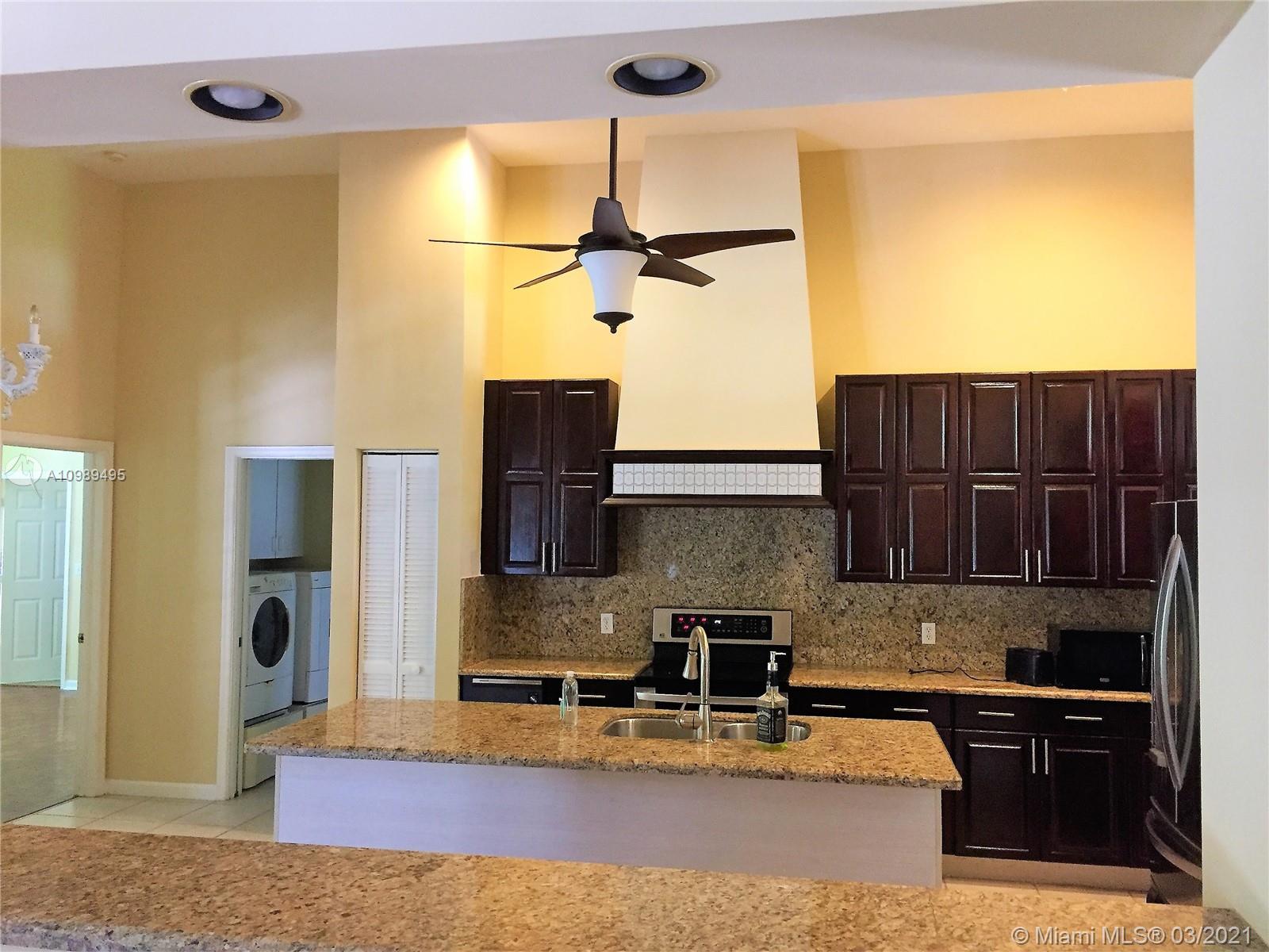 1405 Addison Avenue Boca Raton, FL 33486 - Photo 5 of 24 a kitchen with stainless steel appliances granite countertop a sink refrigerator and cabinets