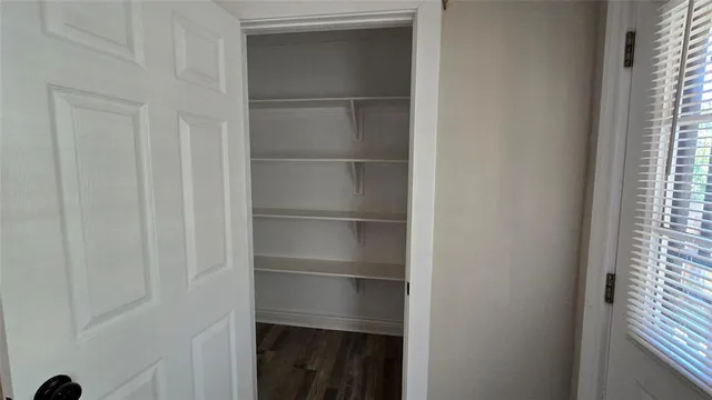a view of walk in closet with empty racks