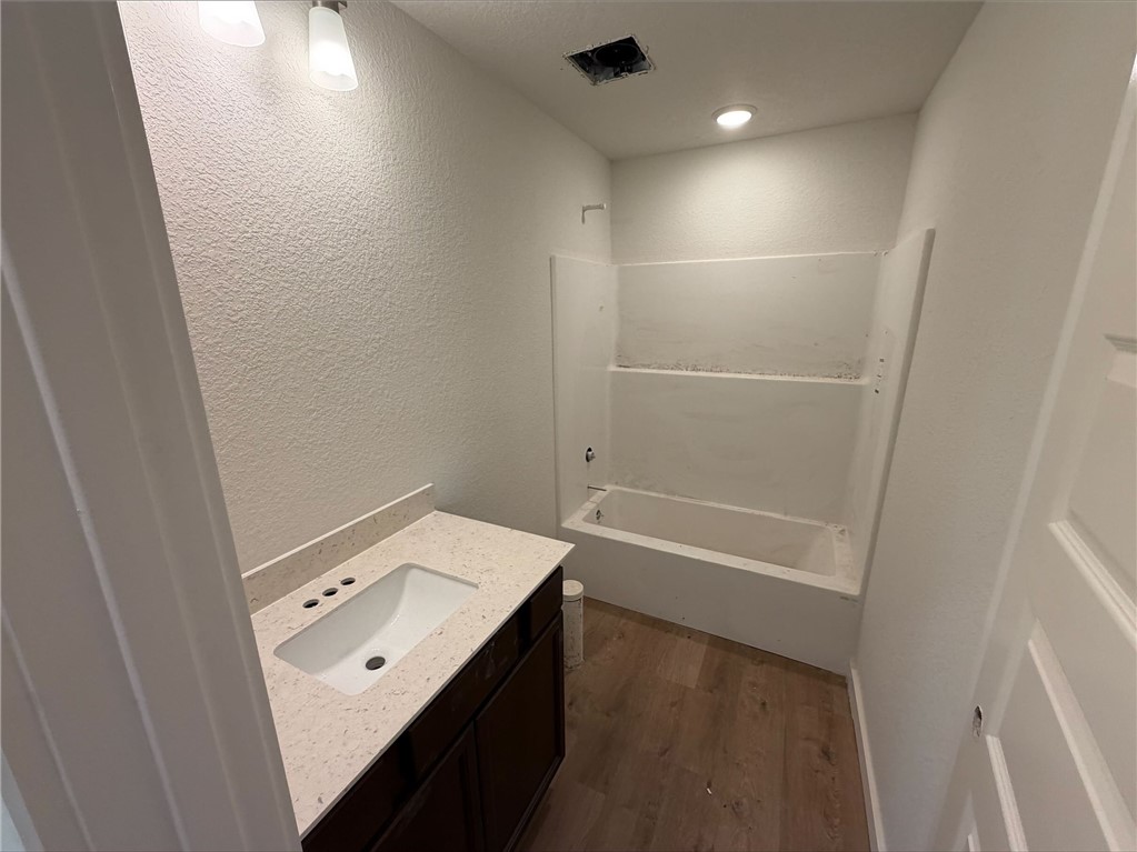 215 Whaley Street Caldwell, TX 77836 - Photo 10 of 14 a bathroom with a bathtub sink vanity and mirror