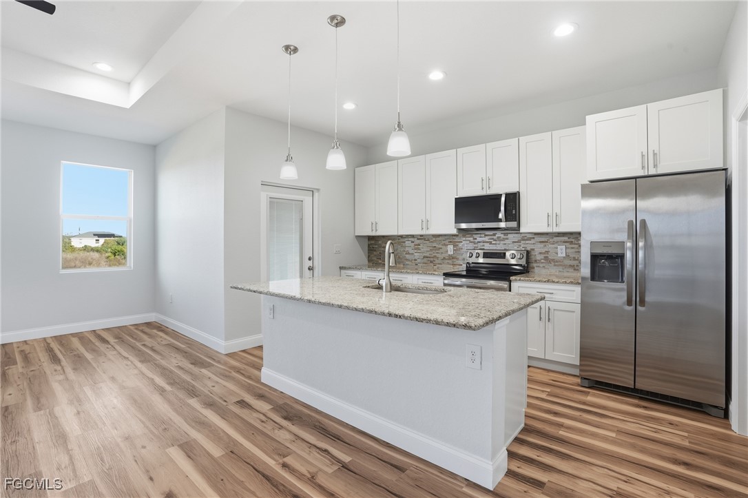 518 Braelyn Street LaBelle, FL 33935 - Photo 12 of 39 a kitchen with granite countertop a refrigerator and a stove top oven