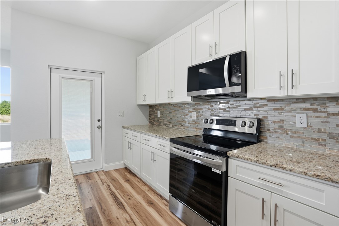 518 Braelyn Street LaBelle, FL 33935 - Photo 16 of 39 a kitchen with stainless steel appliances granite countertop a stove microwave and sink