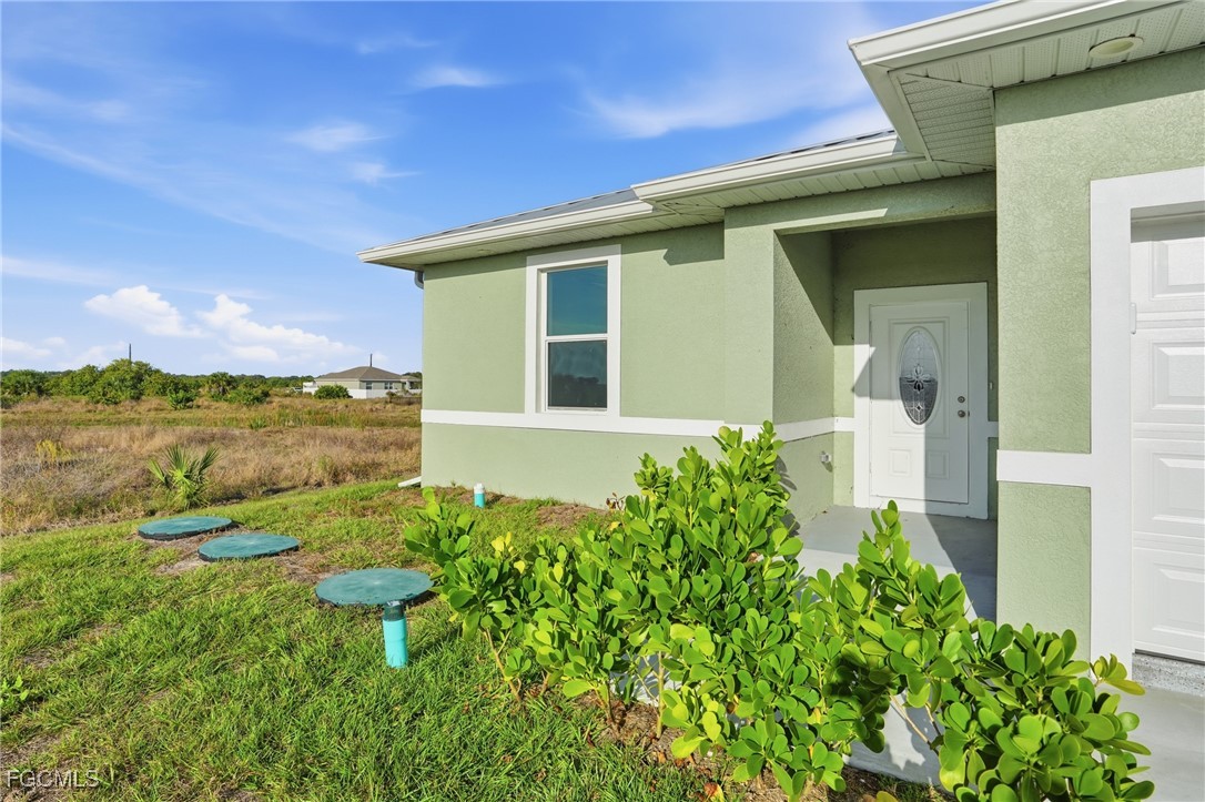 518 Braelyn Street LaBelle, FL 33935 - Photo 2 of 39 a front view of a house with a garden
