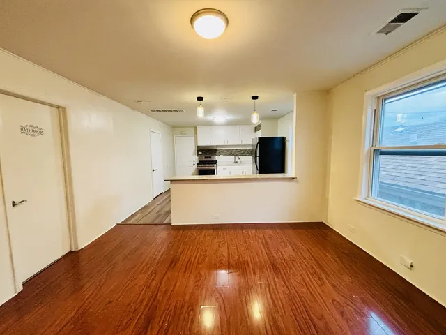 a view of a kitchen with wooden floor and electronic appliances