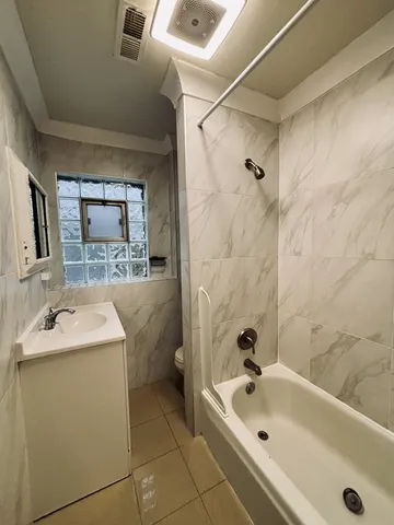 a bathroom with a sink and mirror with bathtub