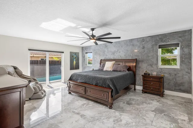 a spacious bedroom with a bed and a flat screen tv